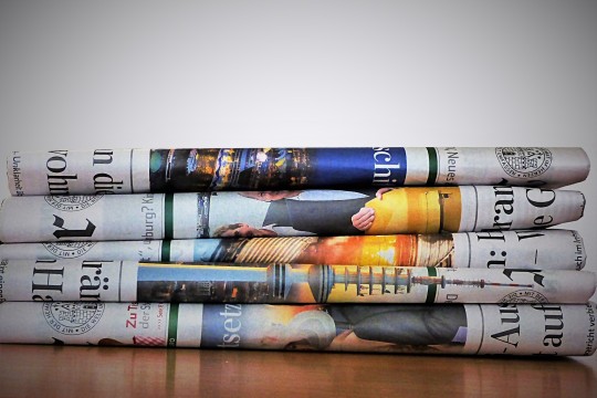 Vier übereinander gestapelte Tageszeitungen.